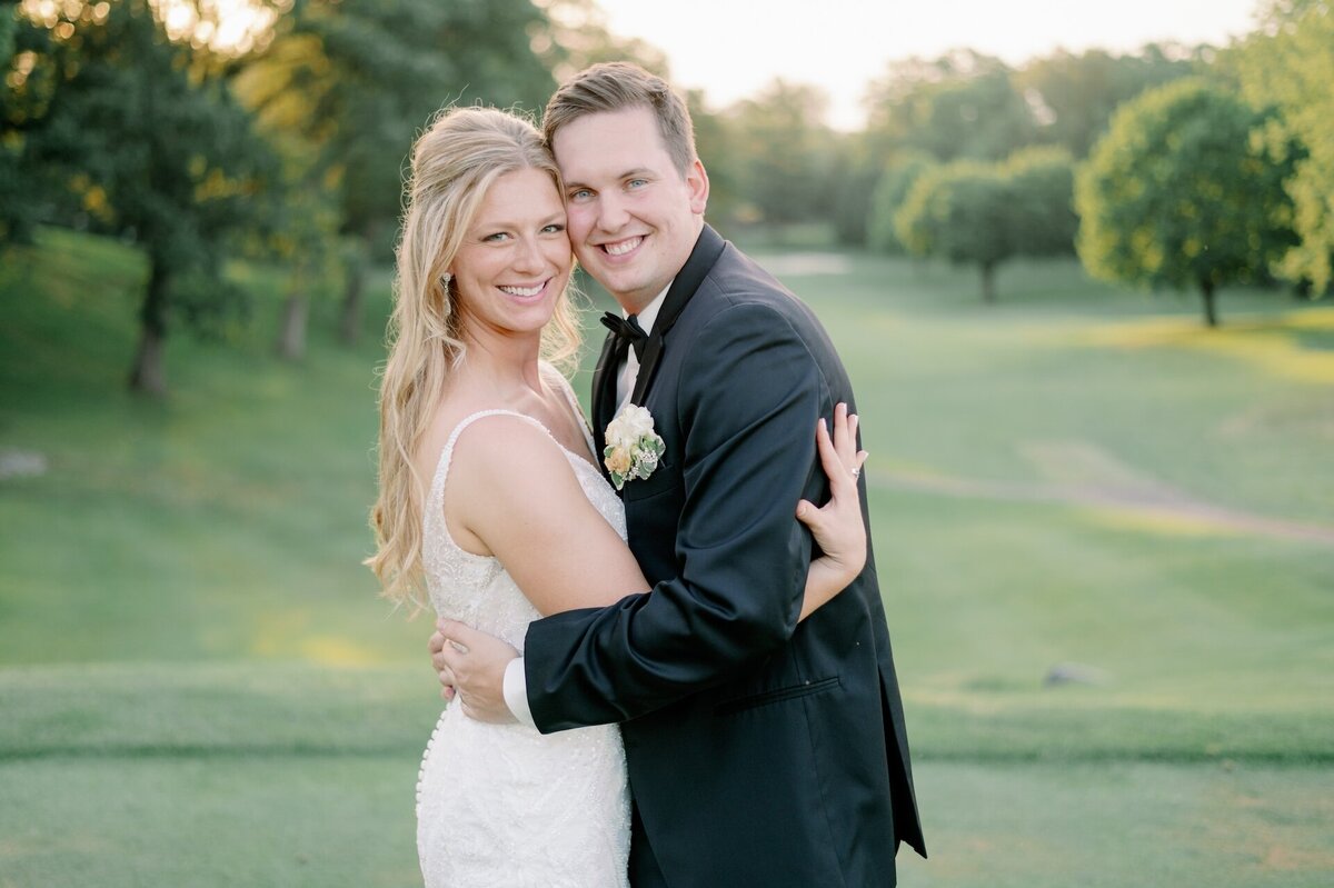 newlyweds posing for a photo on the lawn of Morris Park Country Club