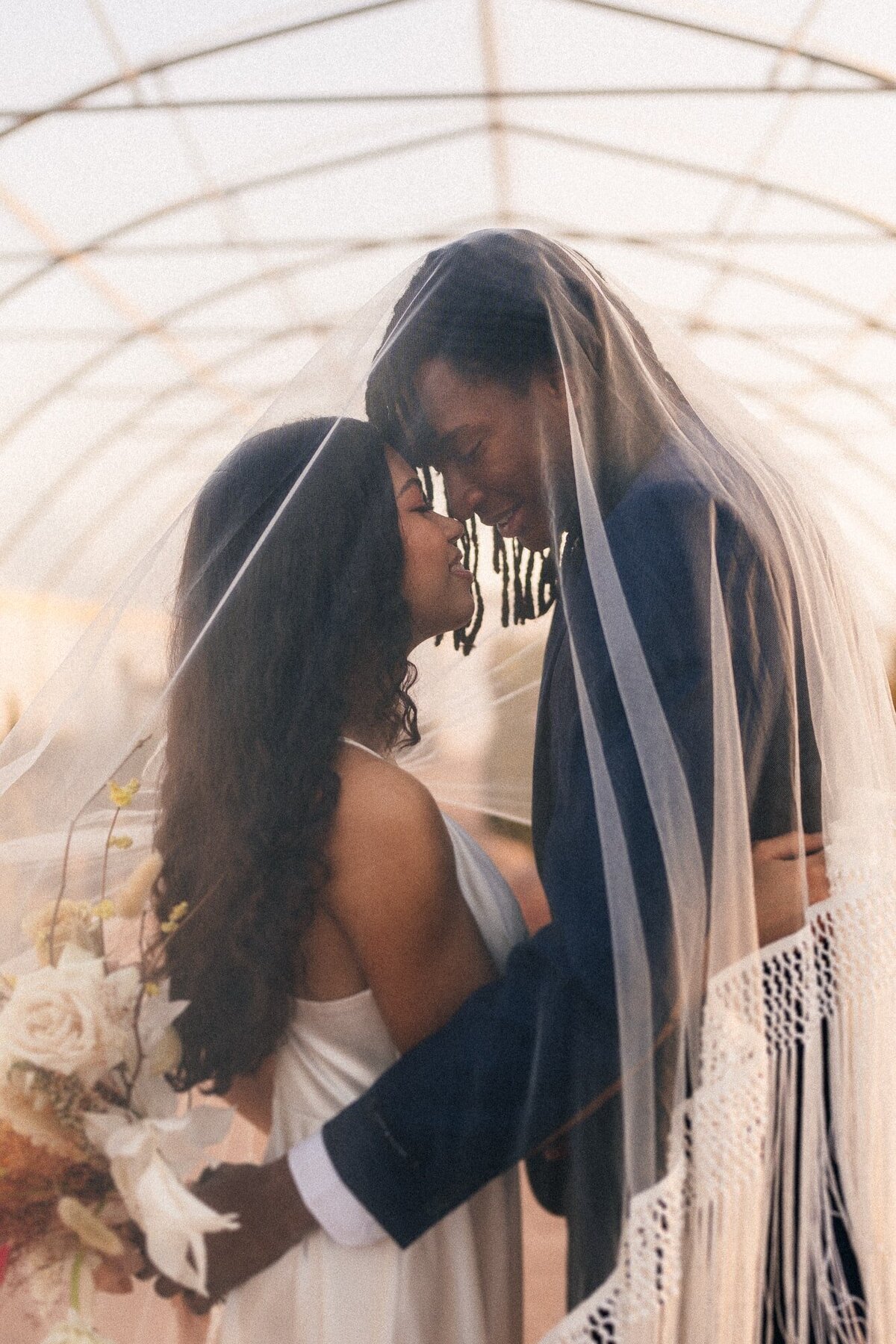 Cherished couple, surrounded by the veil's soft embrace, creating magical memories during their wedding photos at Cactus Joe's in the heart of Las Vegas.