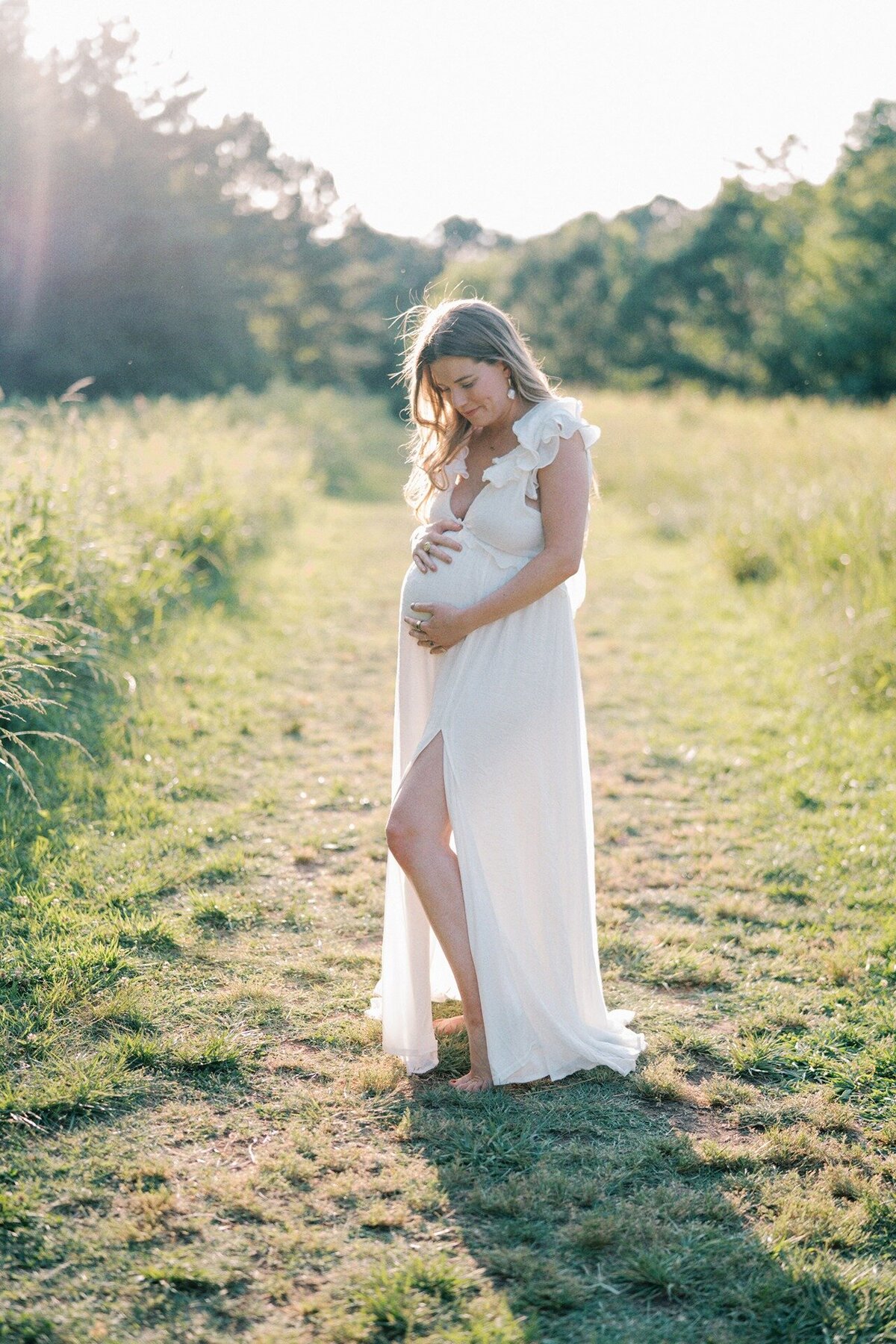 mom-holding-belly-in-field