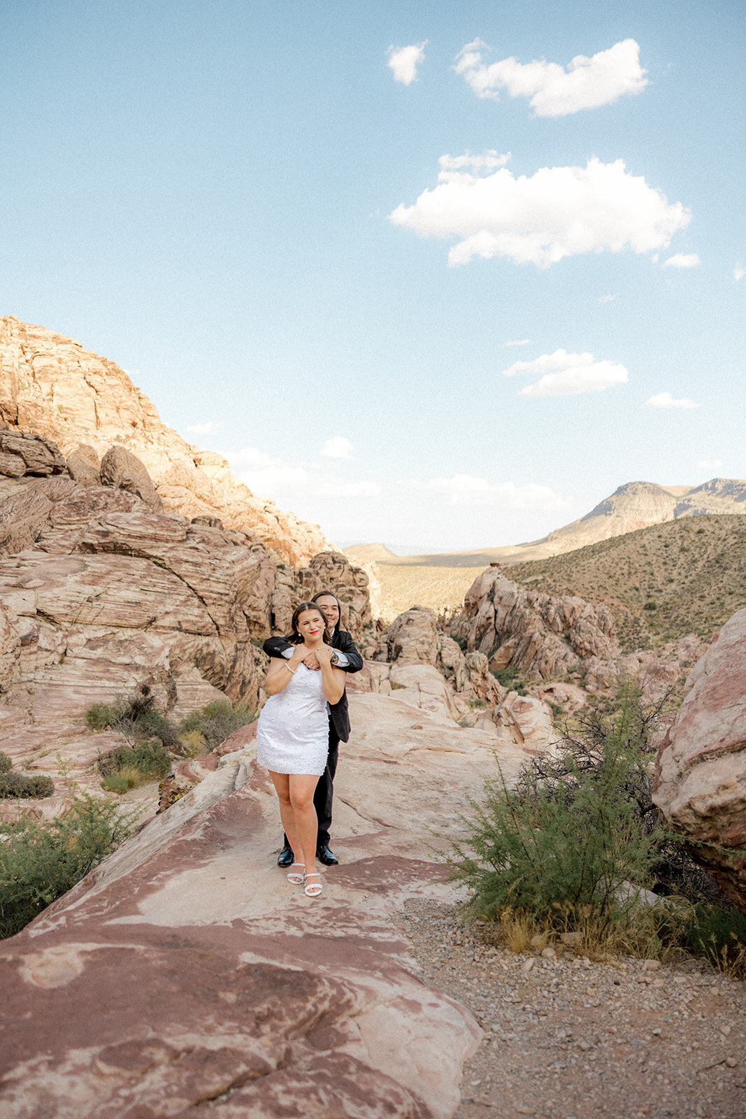 Guy hugging his fiance from behind at the Red Rock Canyon