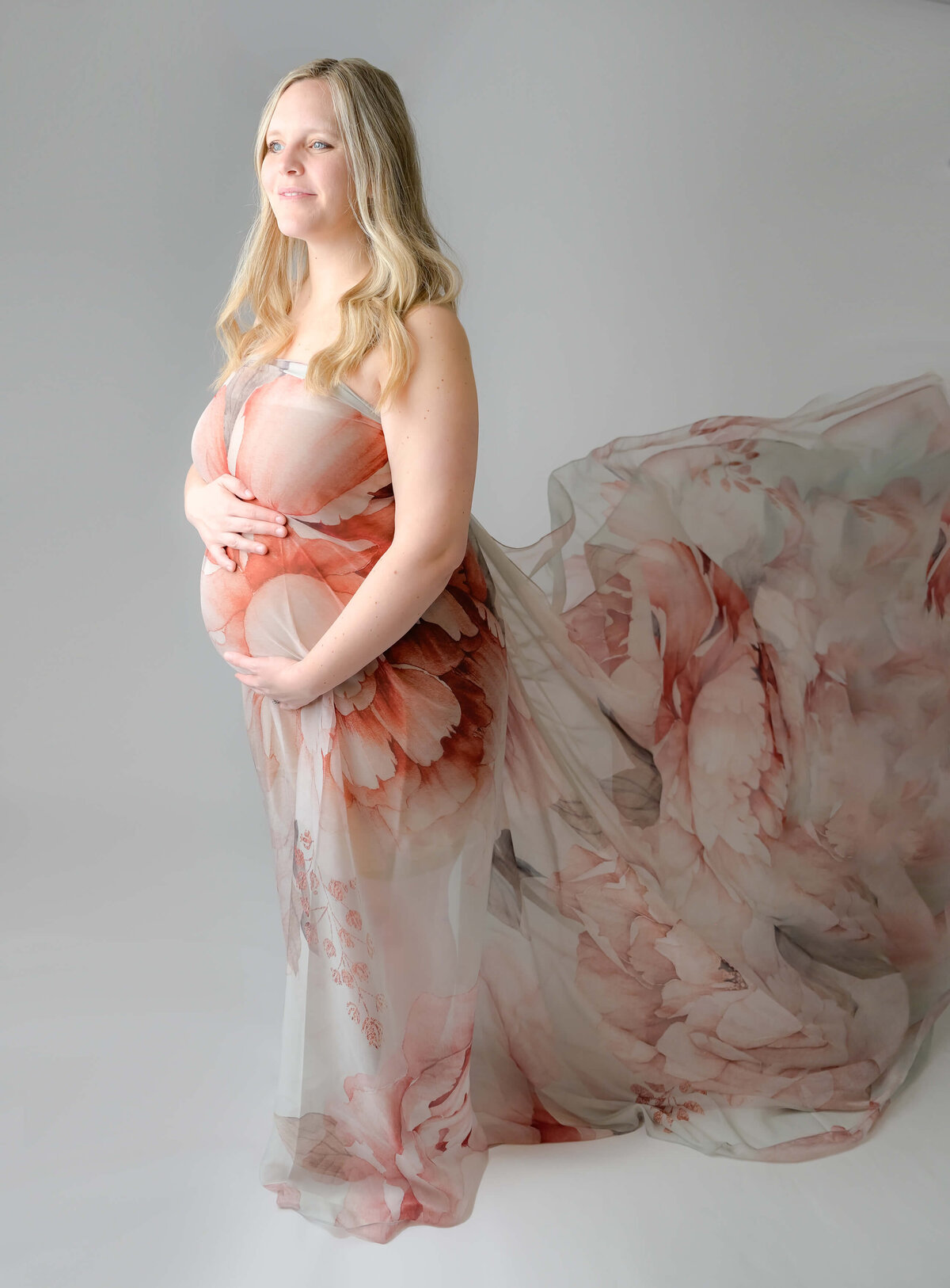 Beth Benecki uses sheer floral fabric to toss to create a stunning visual effect during her maternity photoshoots.