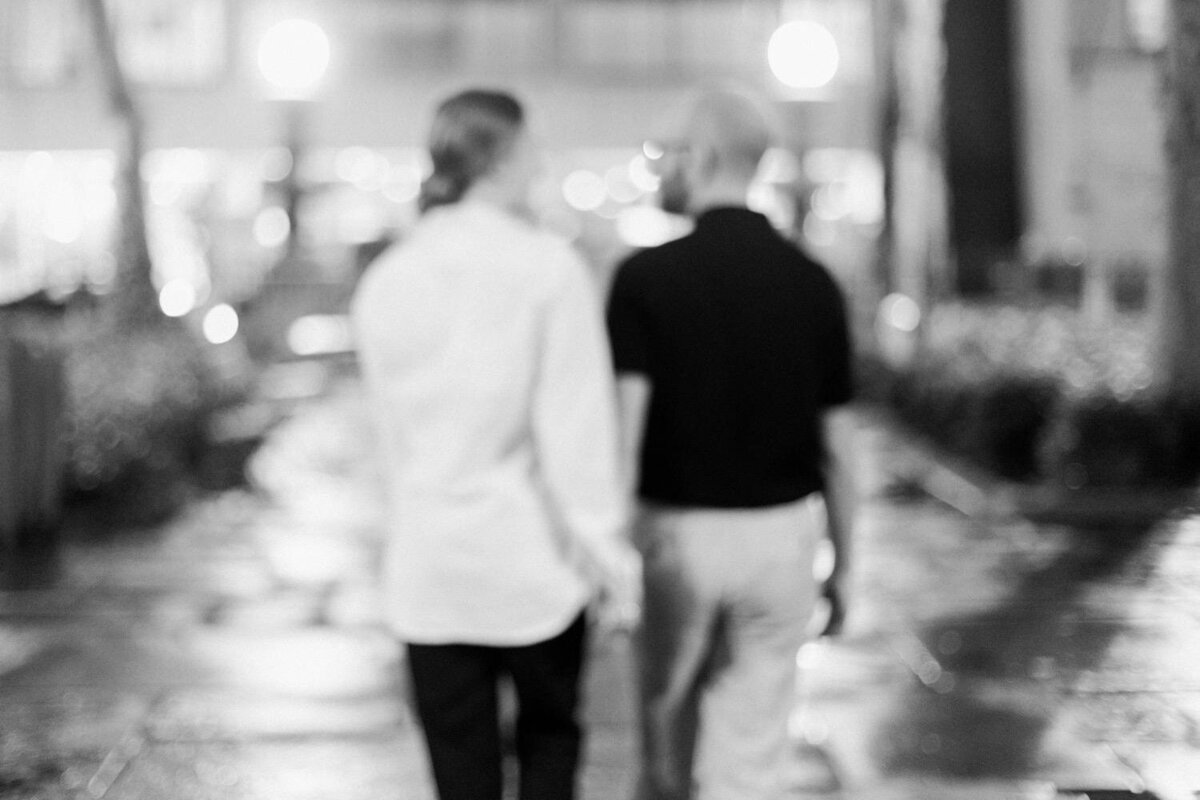 Blurry-black-and-white-image-of-couple-walking-together-at-night-in-New-York-City..jpg