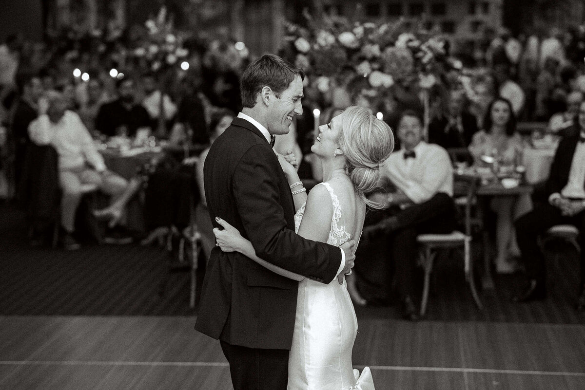 Black and white image of bride and groom dancing at wedding in Texas hill country