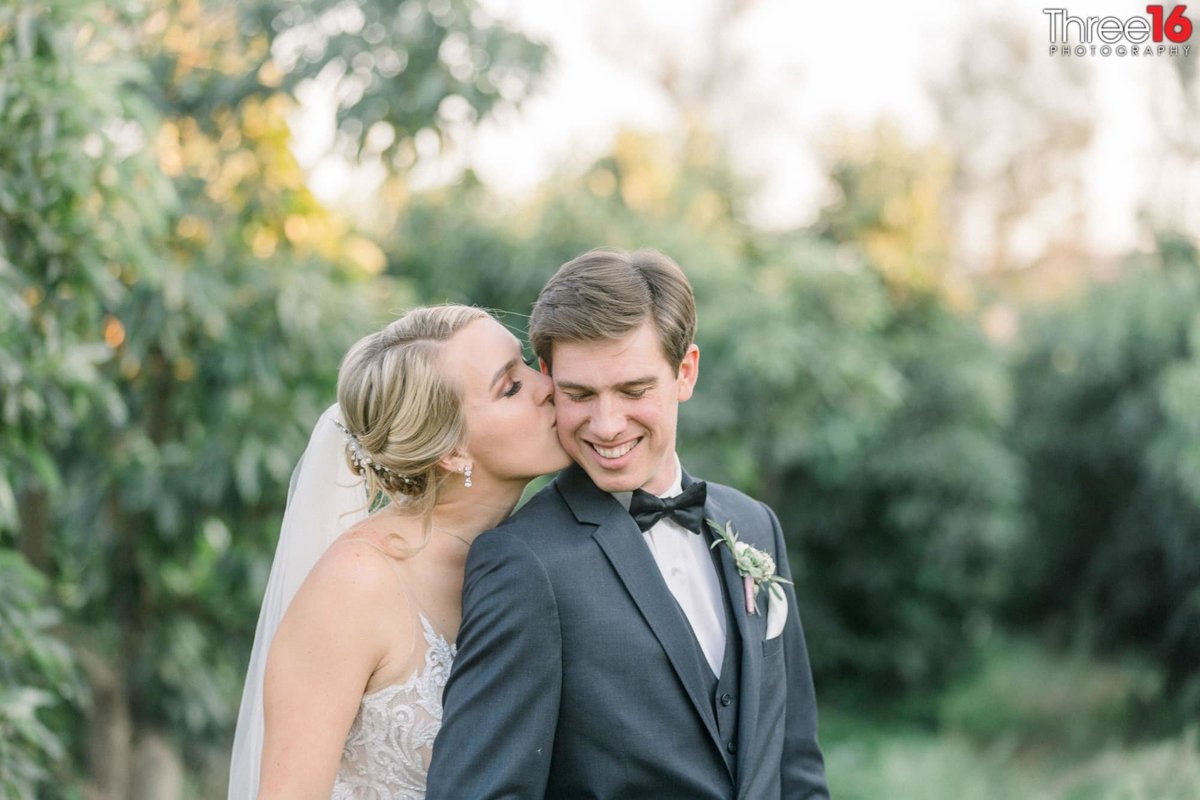 Bride gives her Groom a sweet kiss on his cheek