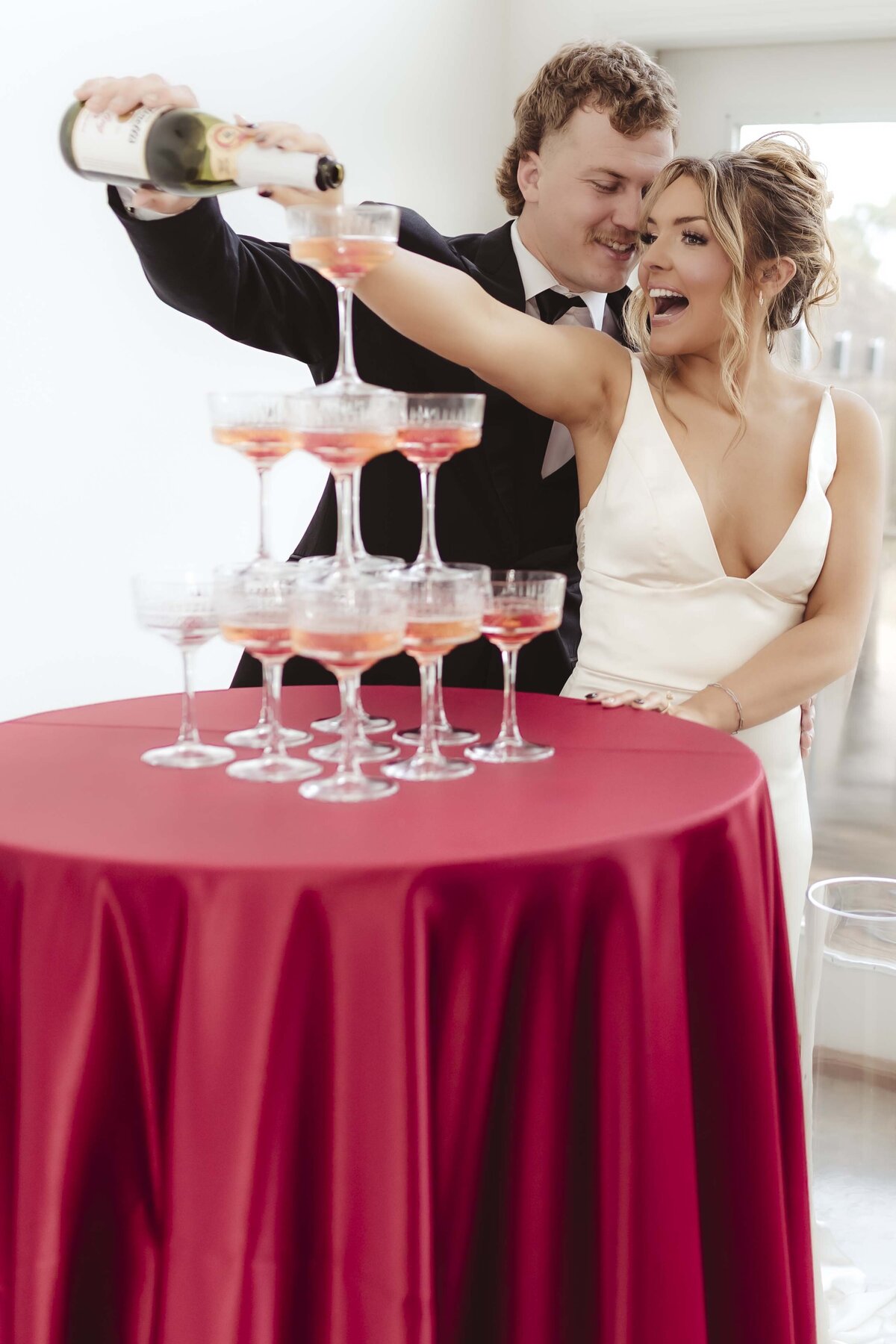 Bride and groom pour champagne on champagne tower with romantic vibes at Missouri wedding venue