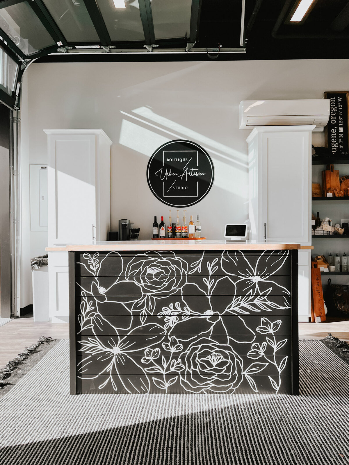 A studio space with a black desk front that features hand-drawn florals on it representing full service design and calligraphy by Life in Letters.