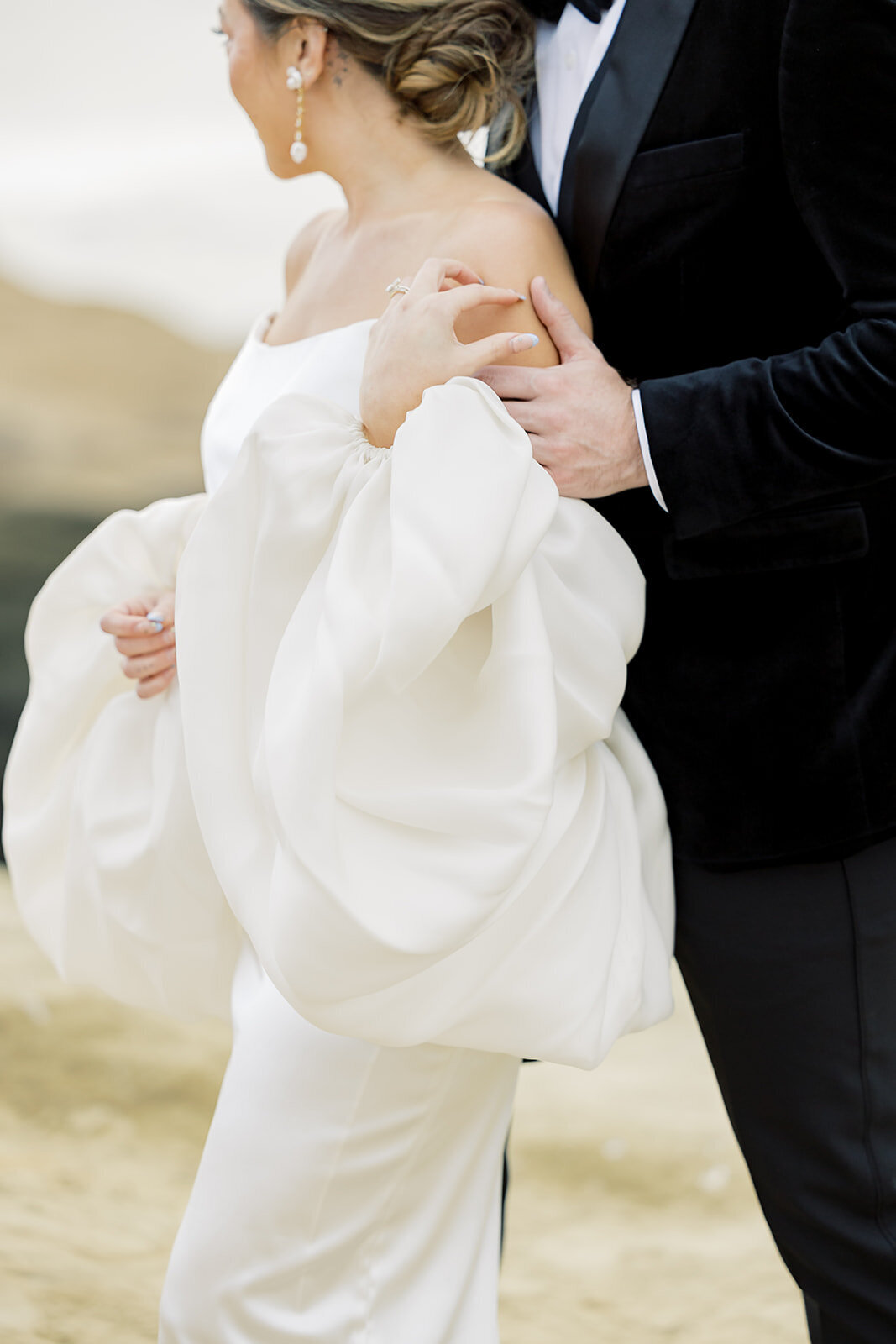 Couple on top off San Diego Cliff holding hands in wedding attire 