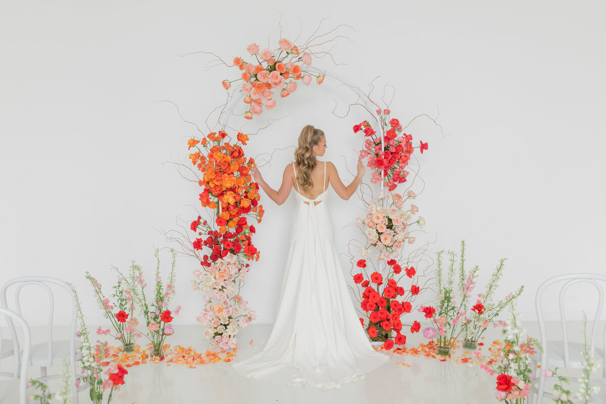 bride surrounded by bright red and orange florals  in supply Manheim in Lancaster