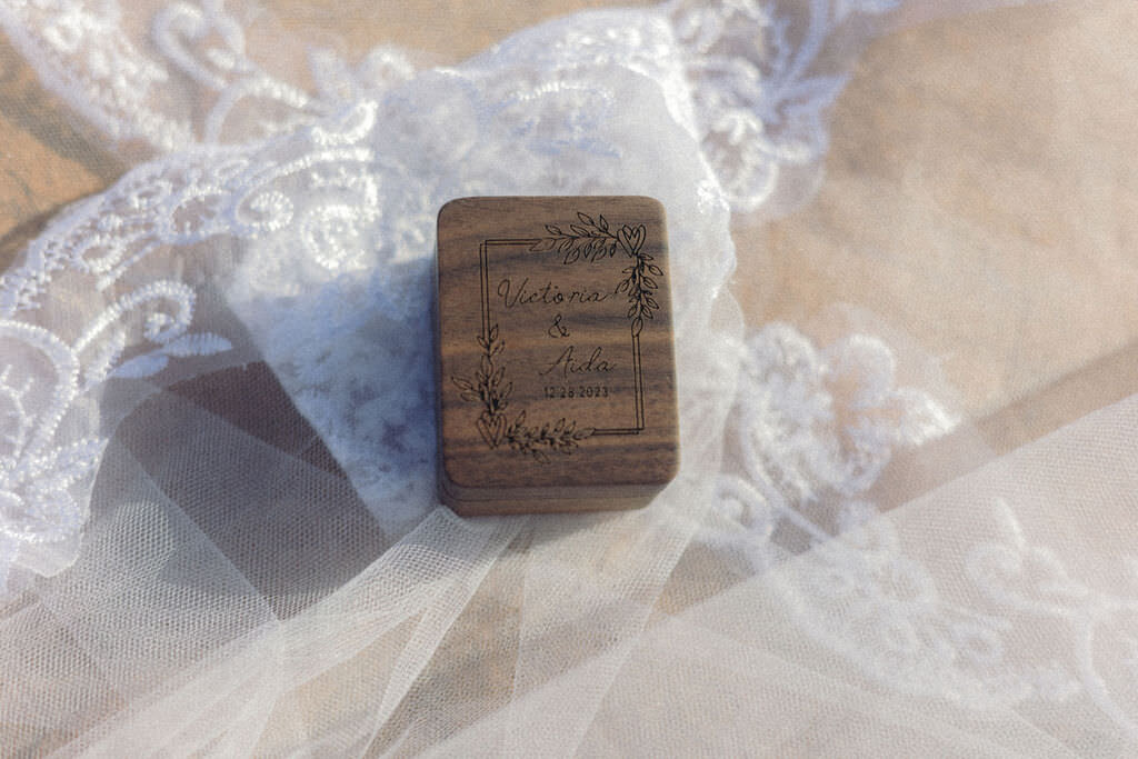 An engraved wooden box sitting on top of a veil.