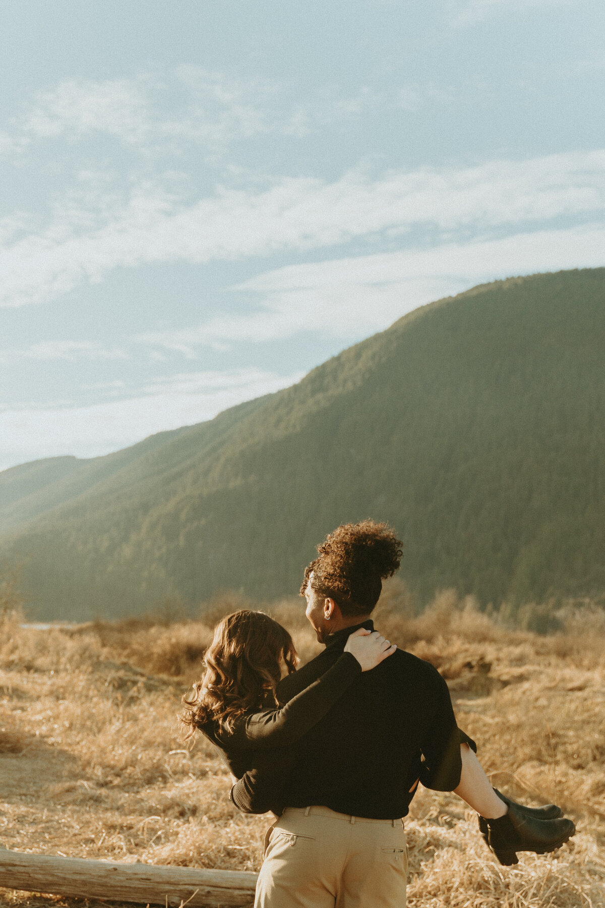 dreamy golden hour engagement photo of a guy carrying his girl