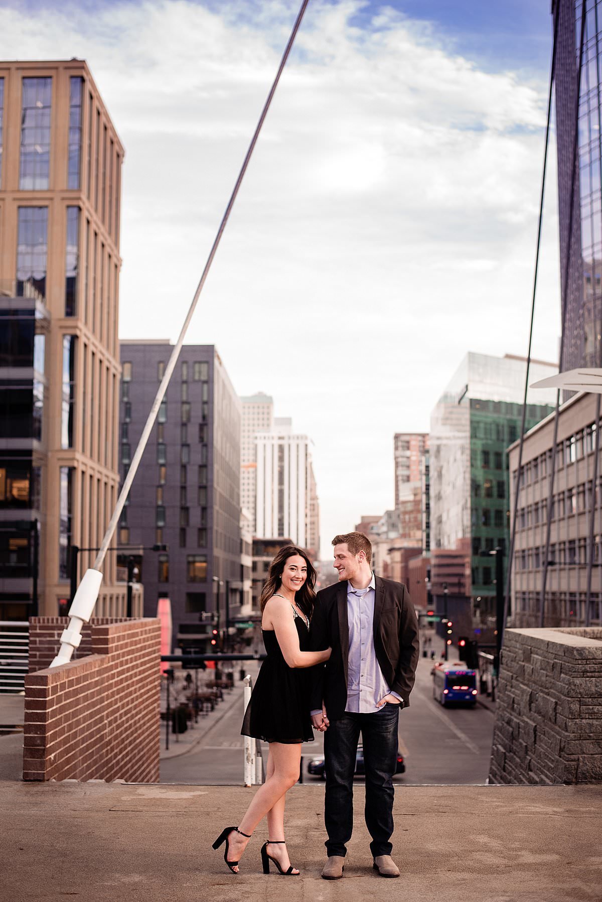 Couple standing together with downtown Denver behind them