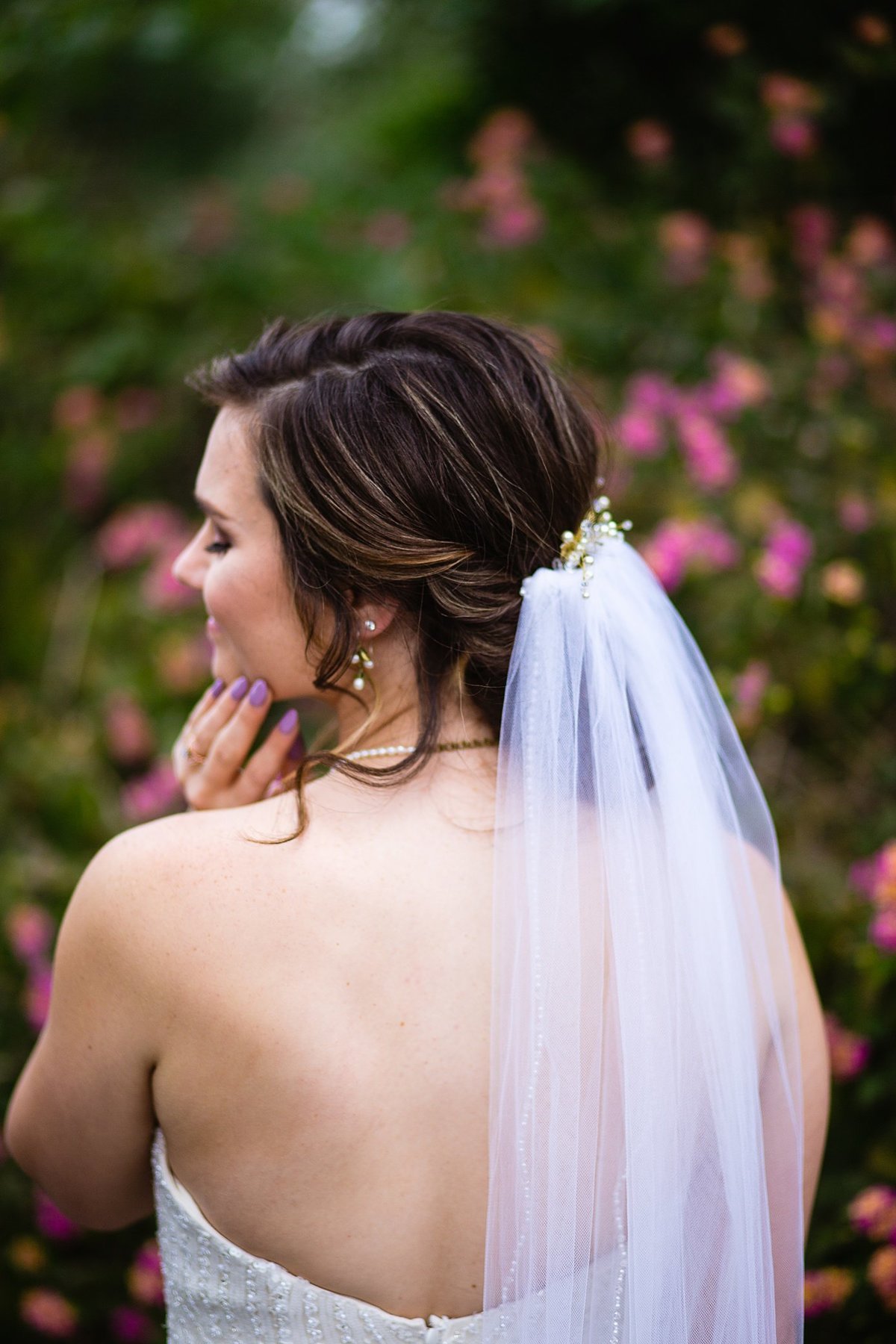 Detail image of the bride's hairstyle and veil in a garden by PMA Photography.