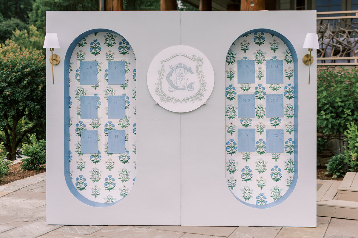 Blue and white custom floral seating chart wall with monogram crest at Trillium Links & Lake Club wedding in Cashiers, North Carolina.
