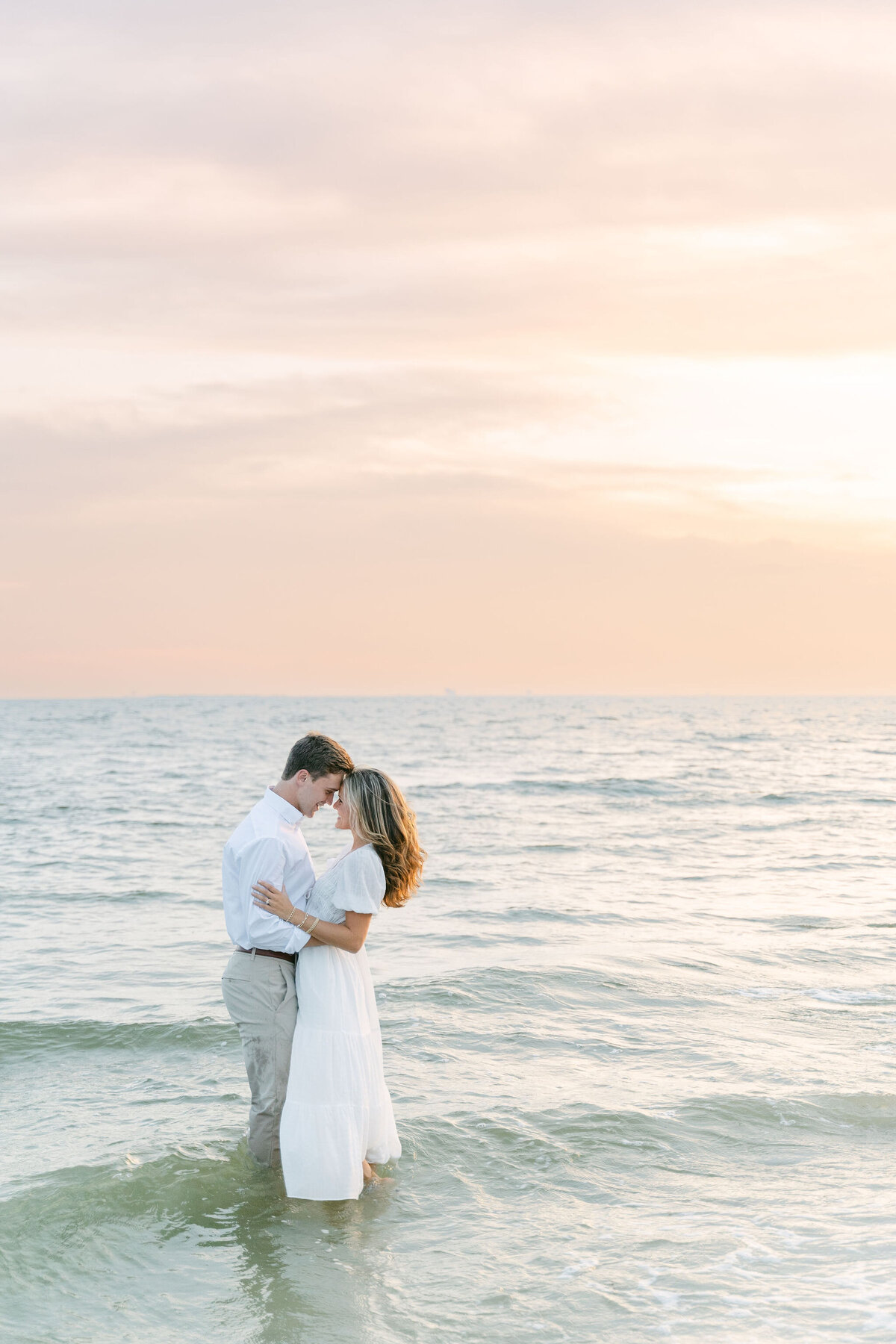 man and woman embracing while standing in the ocean