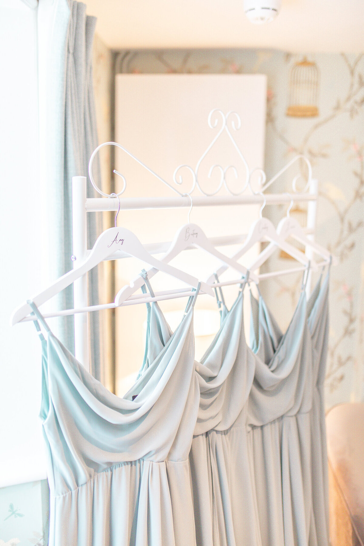 Close up of four pale blue bridesmaids dressing on a hanging rail