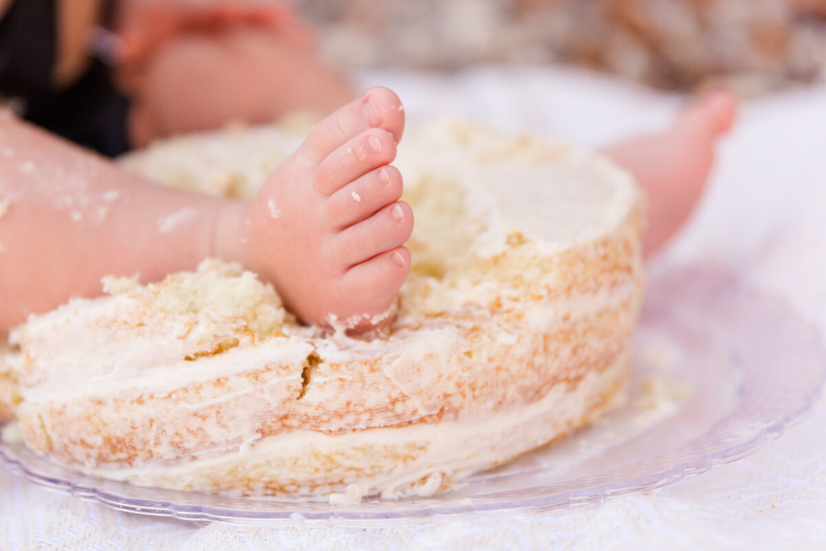 a baby foot smashes a birthday cake