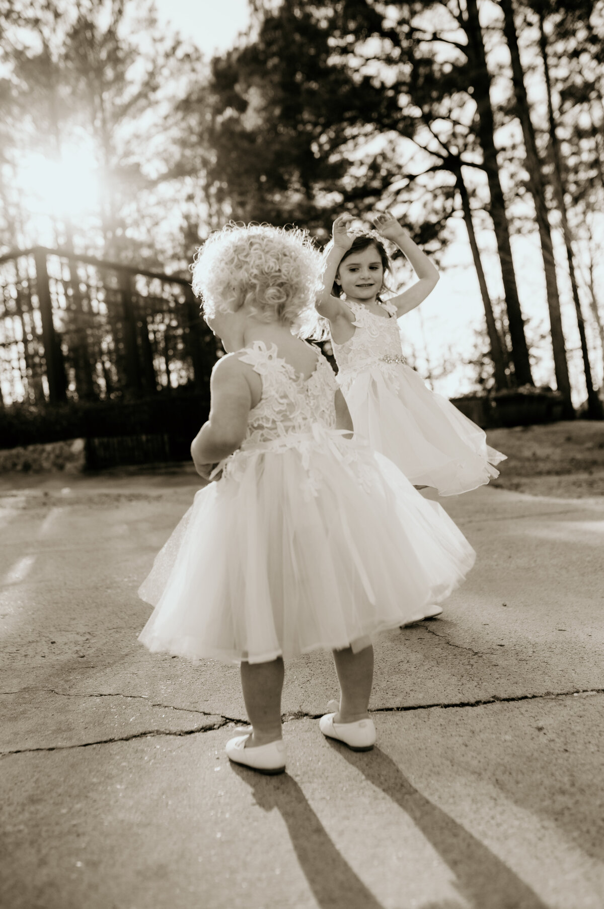 two small children in white dresses dancing in the sunset