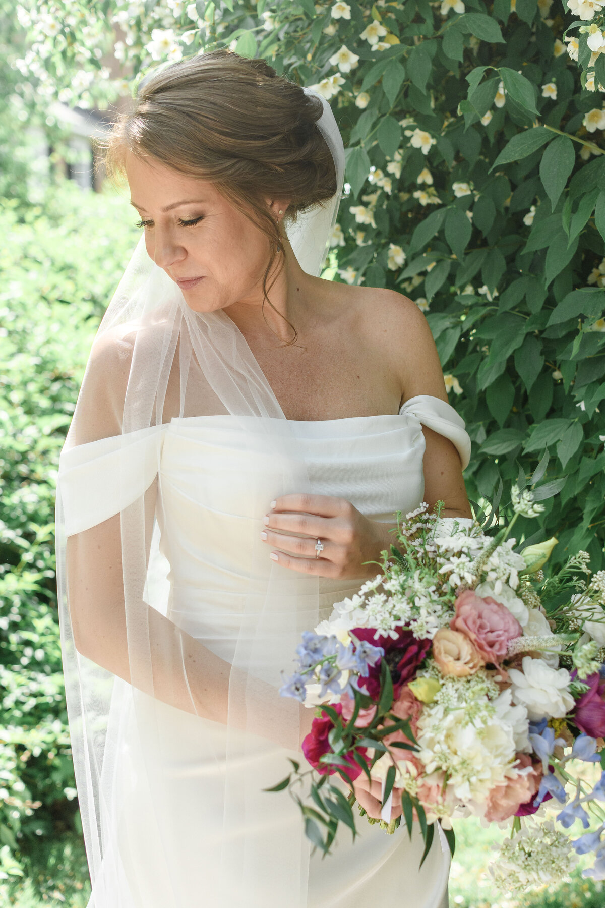 Spring Bride holding her bouquet and veil in soft sunlight at The Preserve at Dundee in Hanover, Virginia