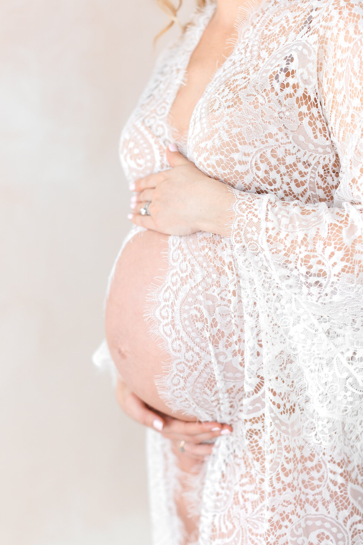 A Northern Virginia Maternity Photographer photo of a pregnant mama's belly in a lace boudoir gown