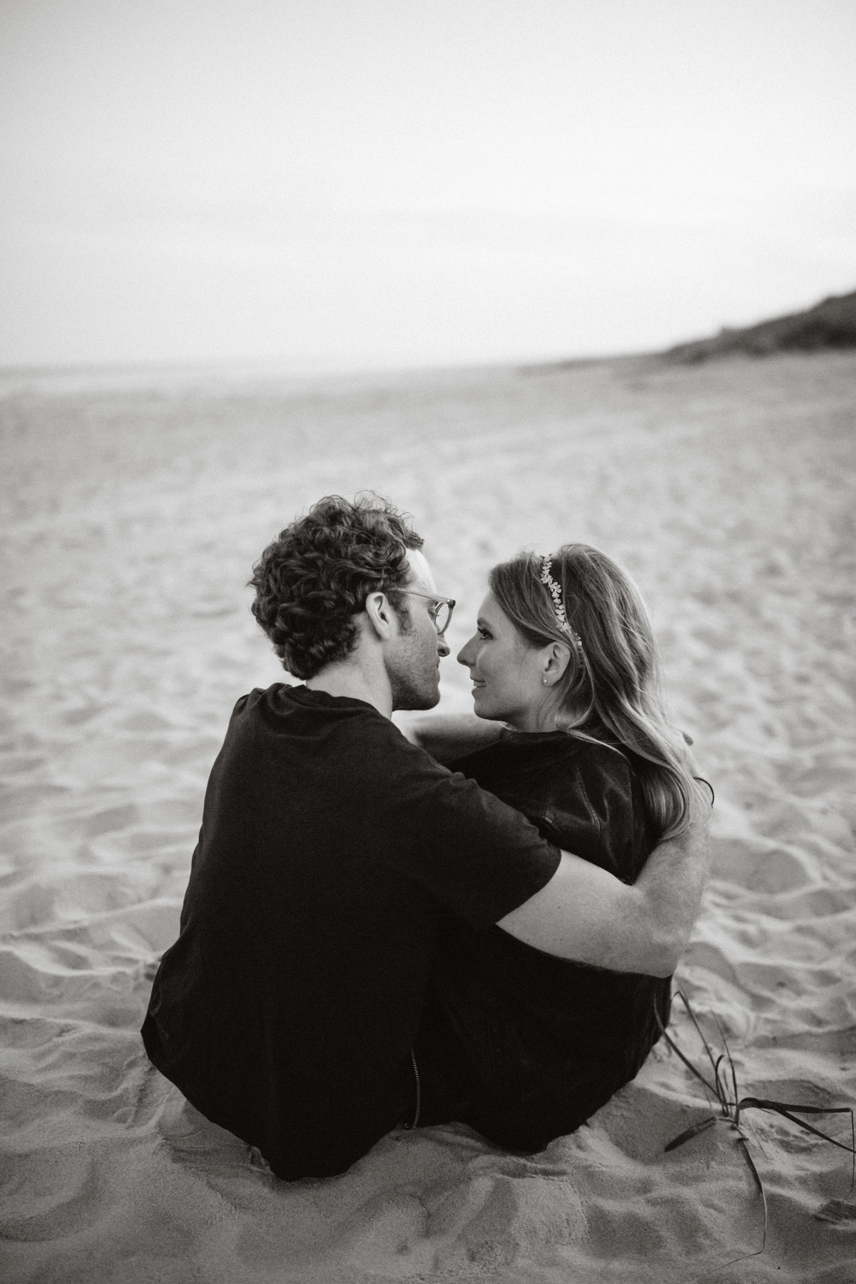 Engaged couple, relax on the beach for their engagement session on Long Island, photographed by Sweetwater.