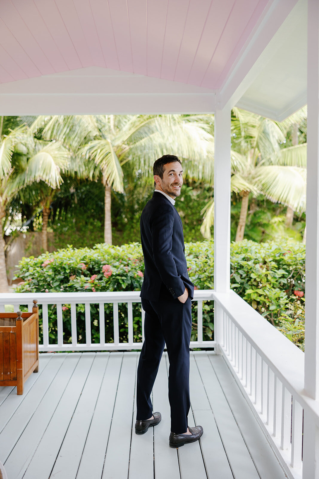 Evan waits for his bride with a smile, standing on the porch of Casitas at Cheeca. Islamorada wedding photography by Claudia Amalia.