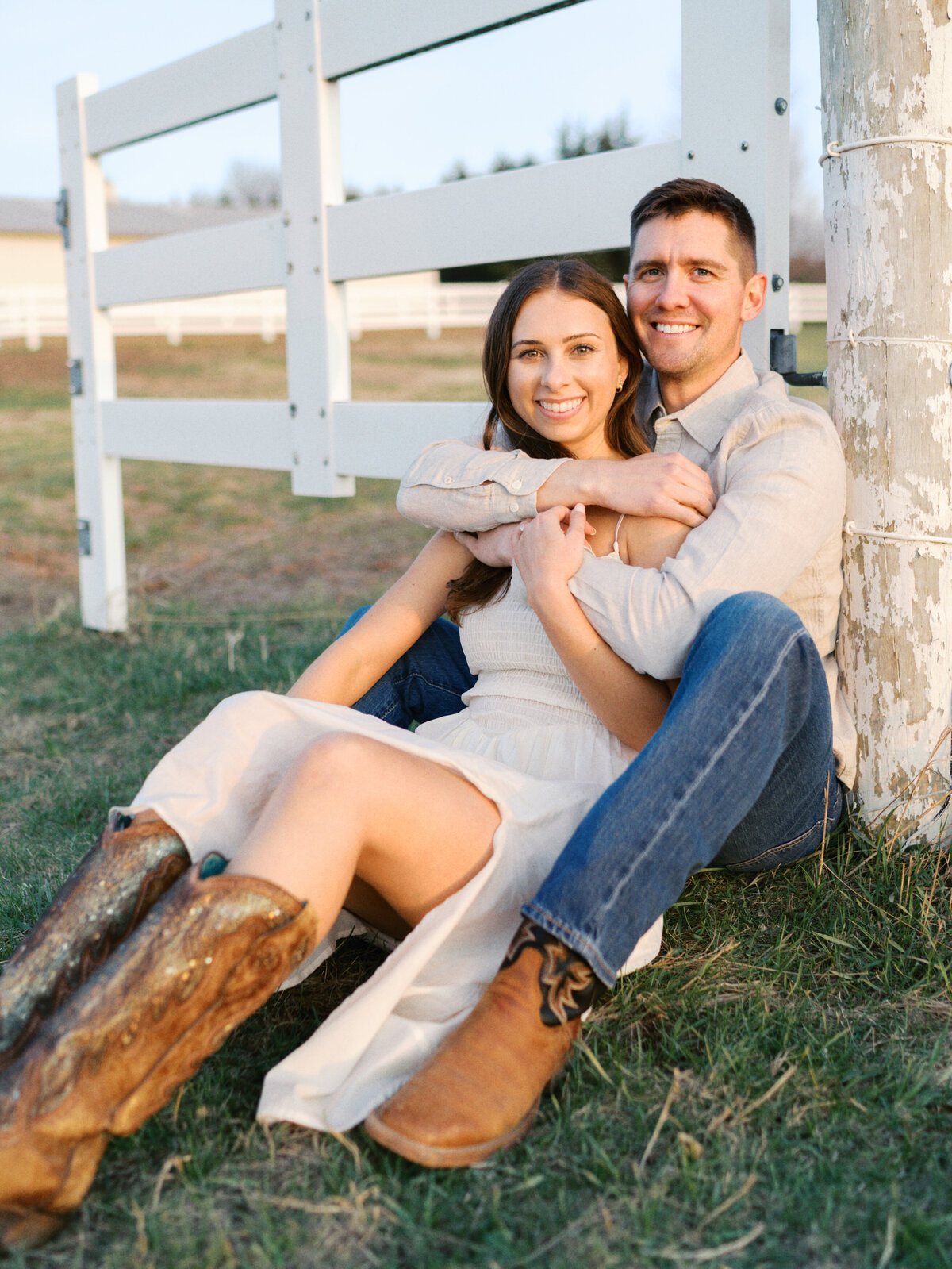couple-sitting-against-fence-post