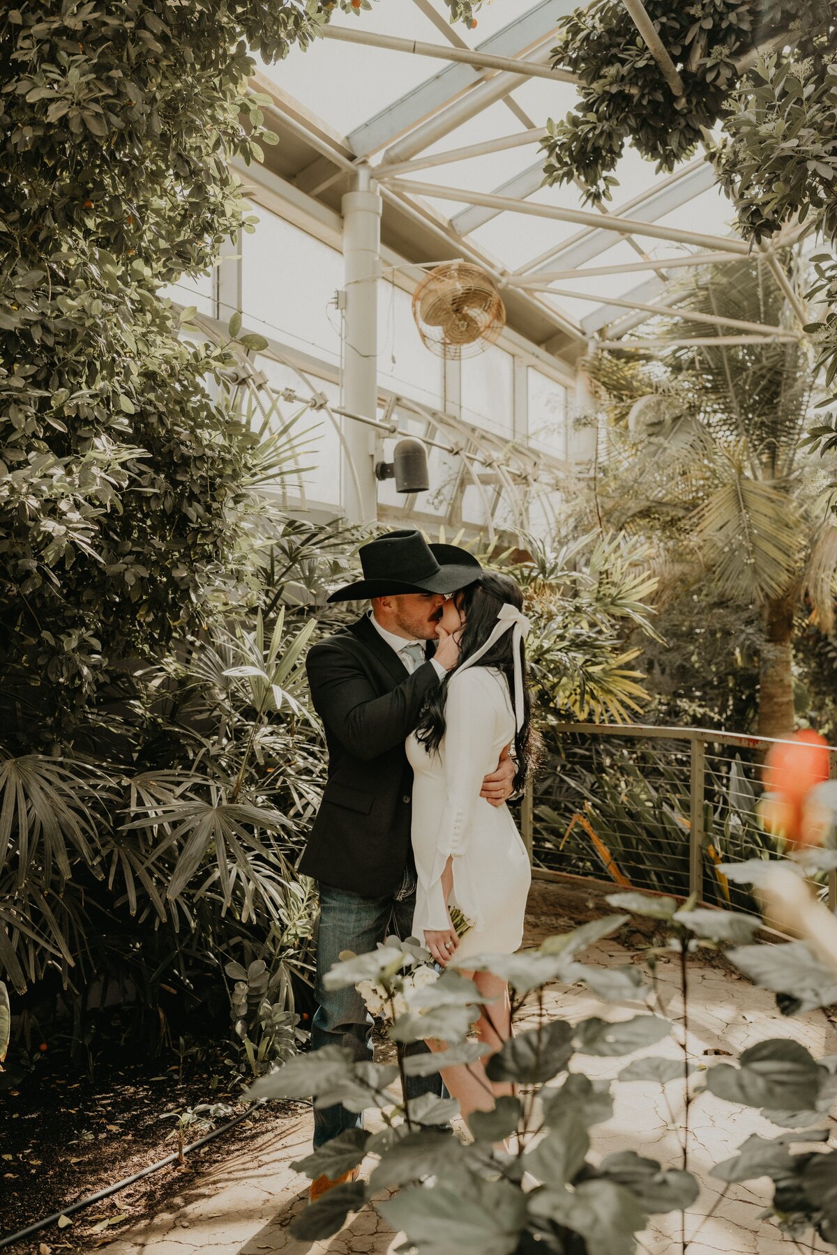 wedding couple kissing in greenhouse at amarillo botanical gardens, , Emily wheeler photography