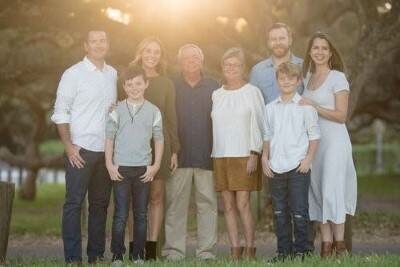 Beautiful extended family of eight posing outdoors during golden hour family photo session in St Augustine FL
