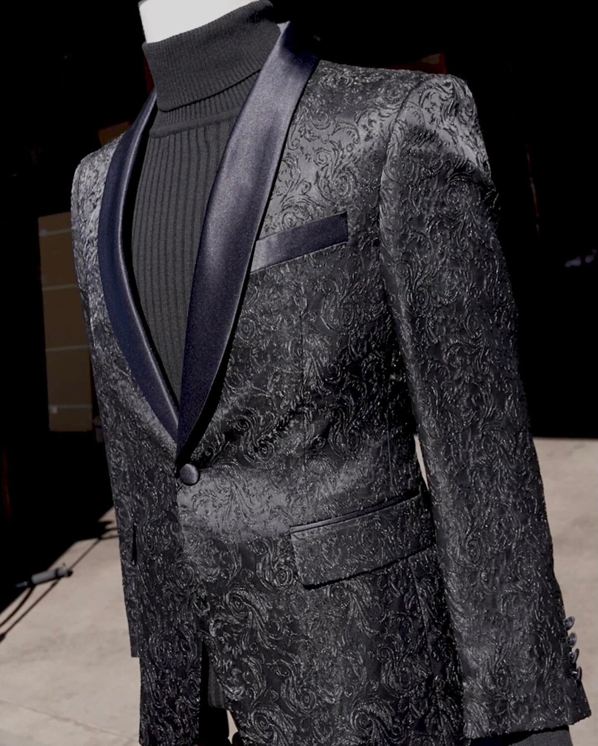 A Quinceañera suit on a mannequin featuring intricate embroidery