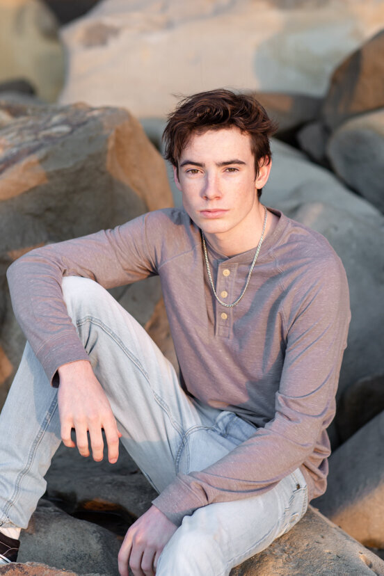 portrait-of-teen-boy-sitting-on-rocks-la-jolla-beach-san-diego