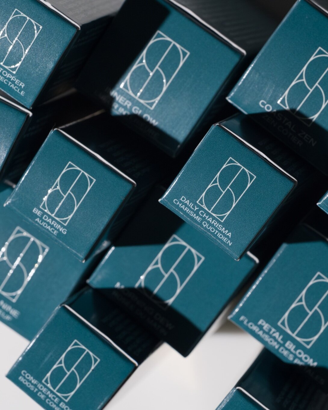 Teal product box tops with Sonela Beauty’s brand icon