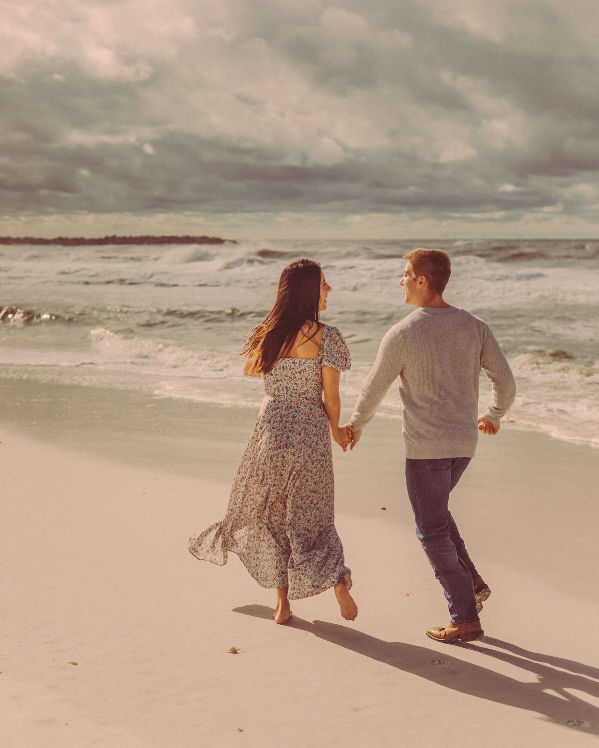 newly engaged ben & ashley run down panama city beach holding hands