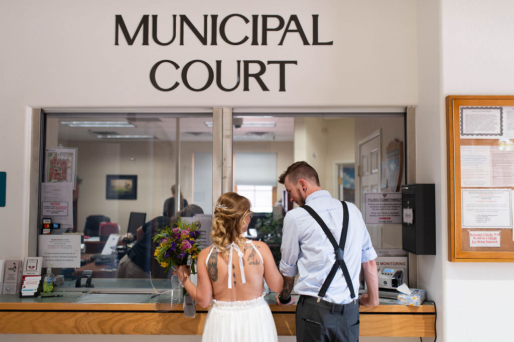 A wedding couple standing at a checkin desk for the municipal court.