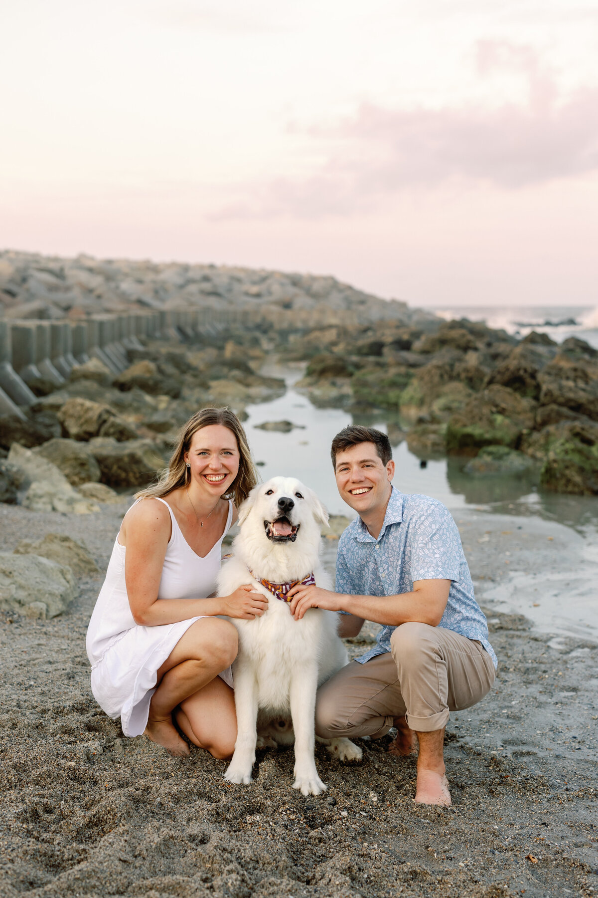 Engaged couple posing with their dog on Wilmington beach, casual engagement photo