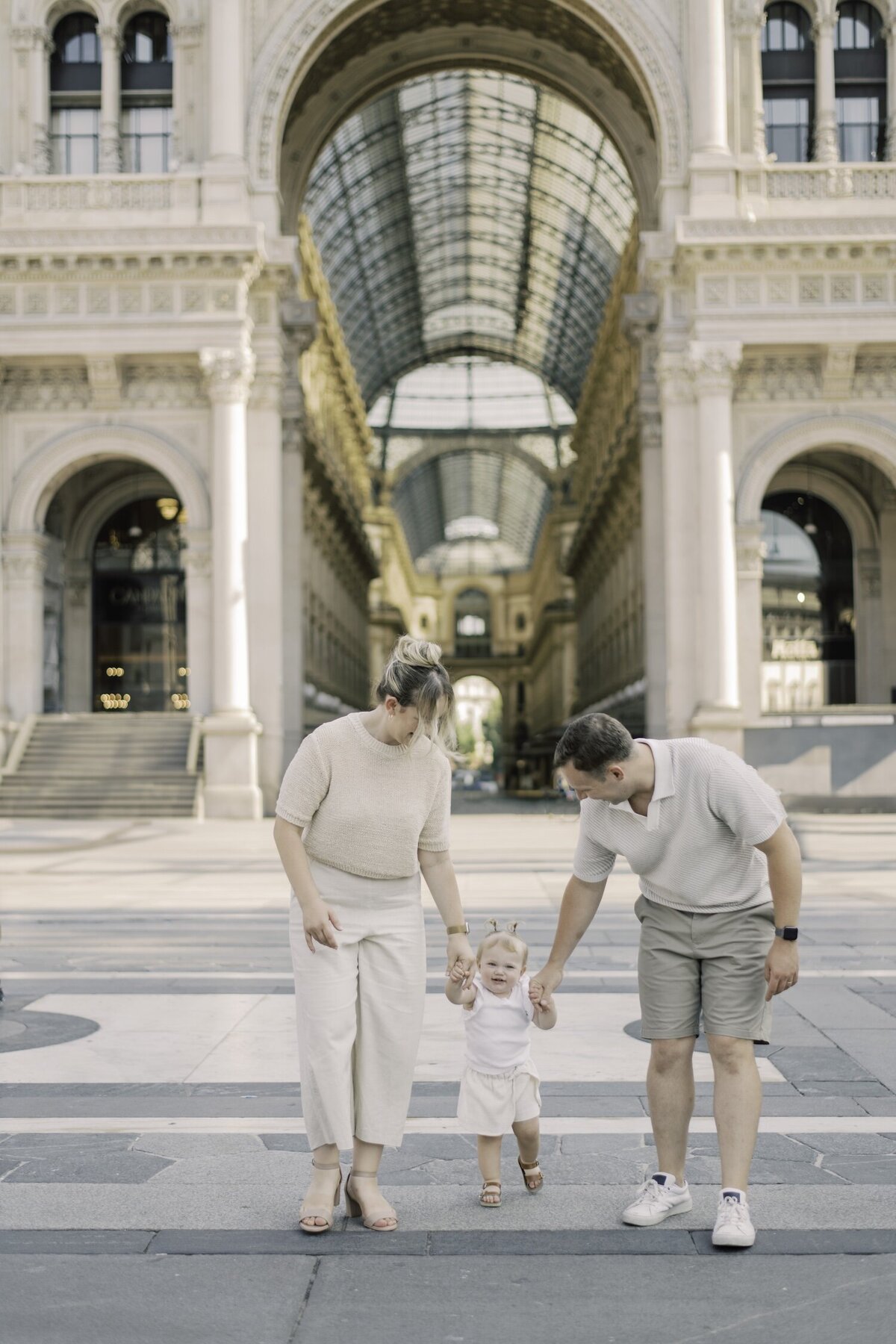 Parents and children walking joyfully through Milan’s Galleria during their lifestyle family session