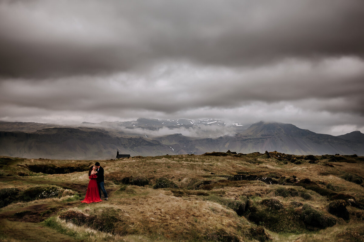 Couple standing in the lava fields By the church in Budir