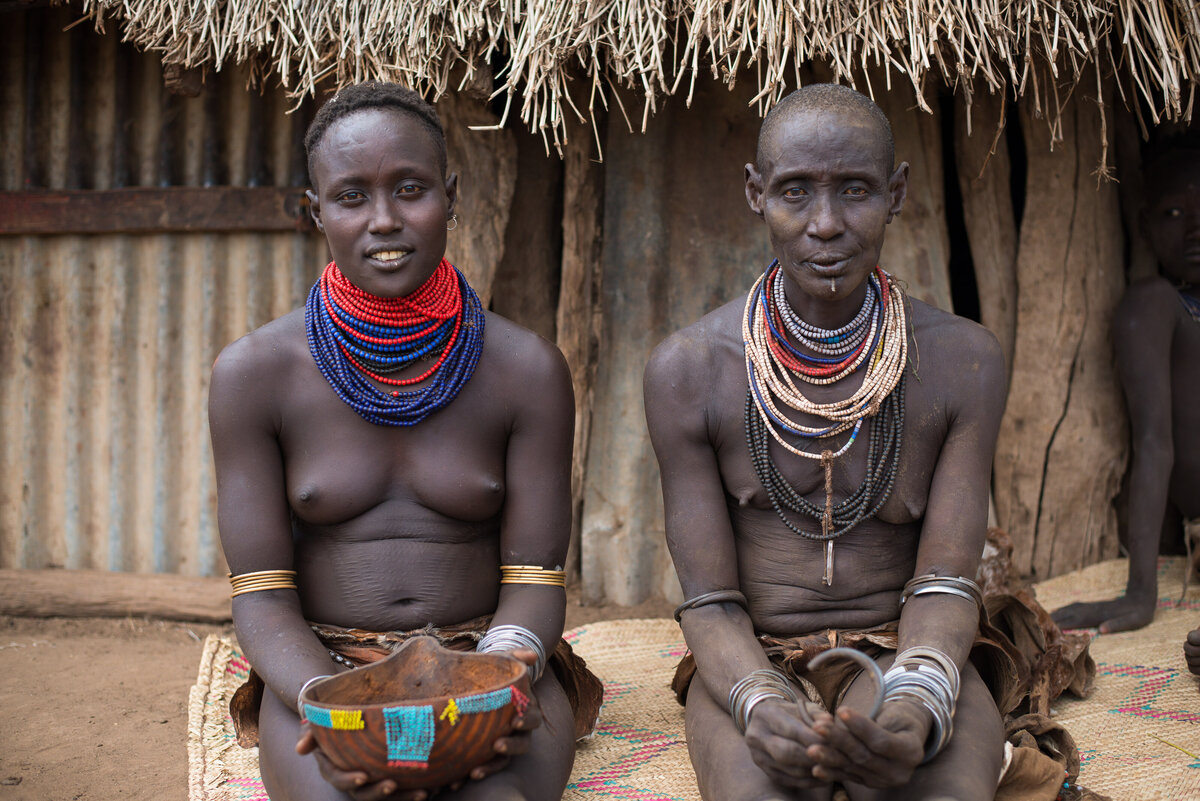 kara tribe women pose for camera