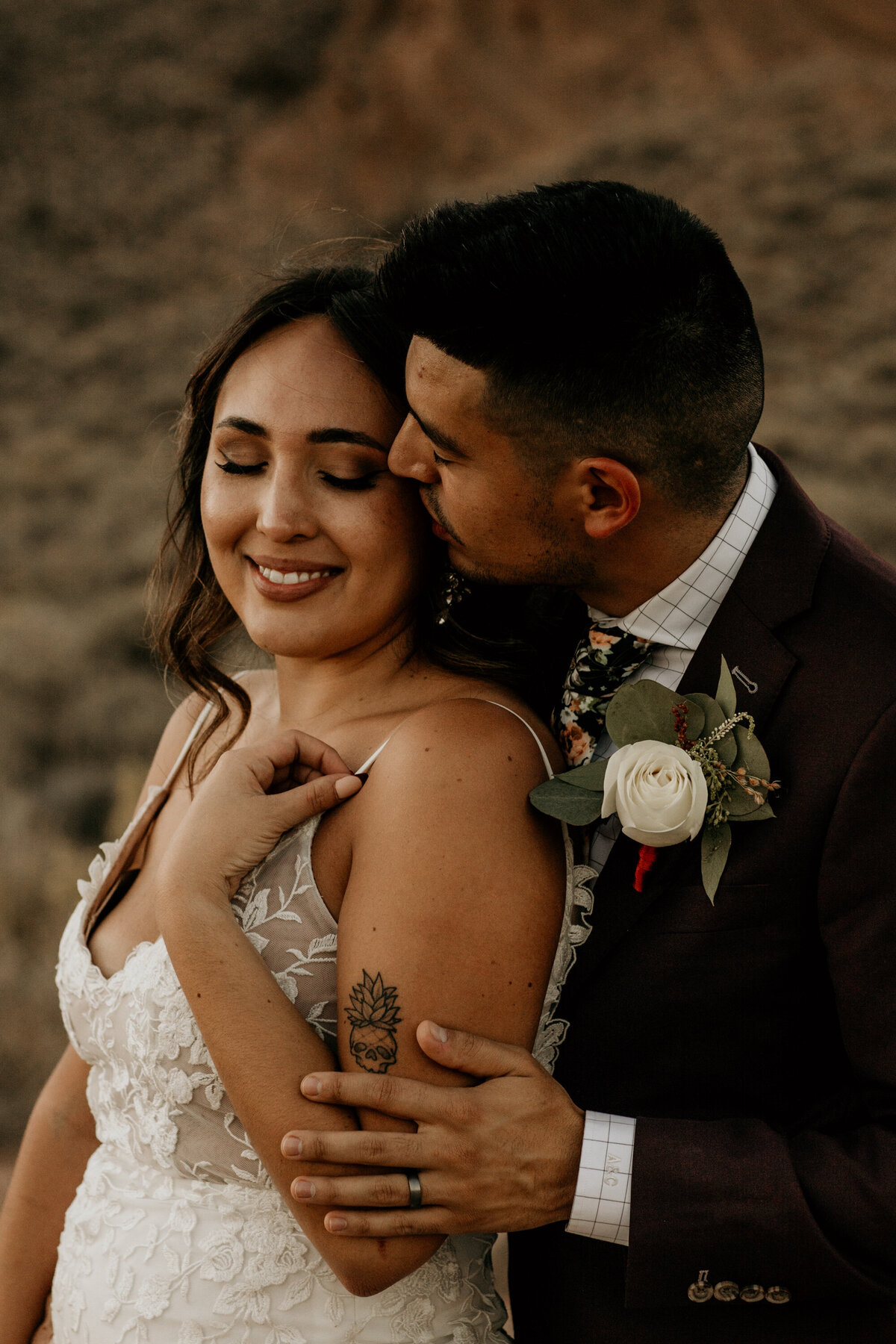 groom kissing brides cheek from behind