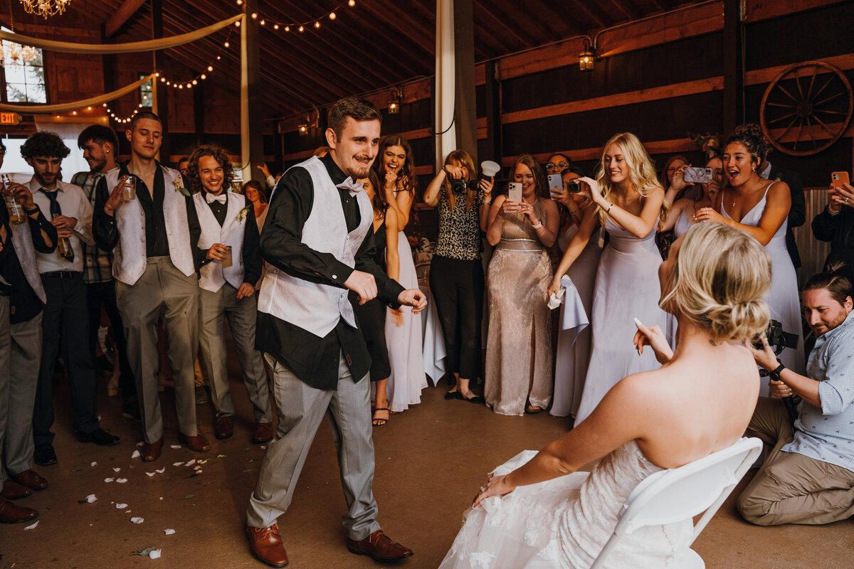 Groom dancing in front of sitting bride