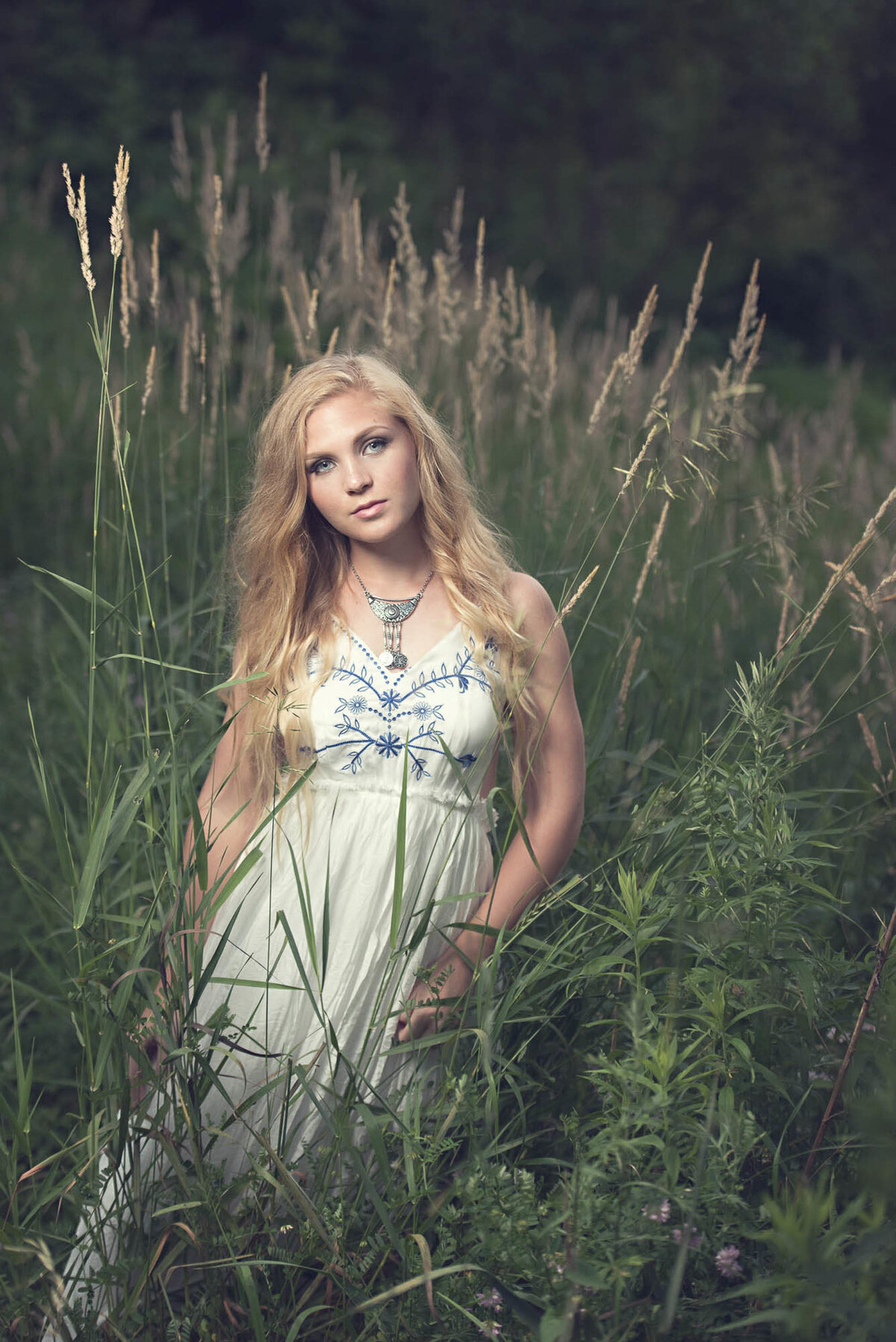 Blonde senior girl in field white dress photographer
