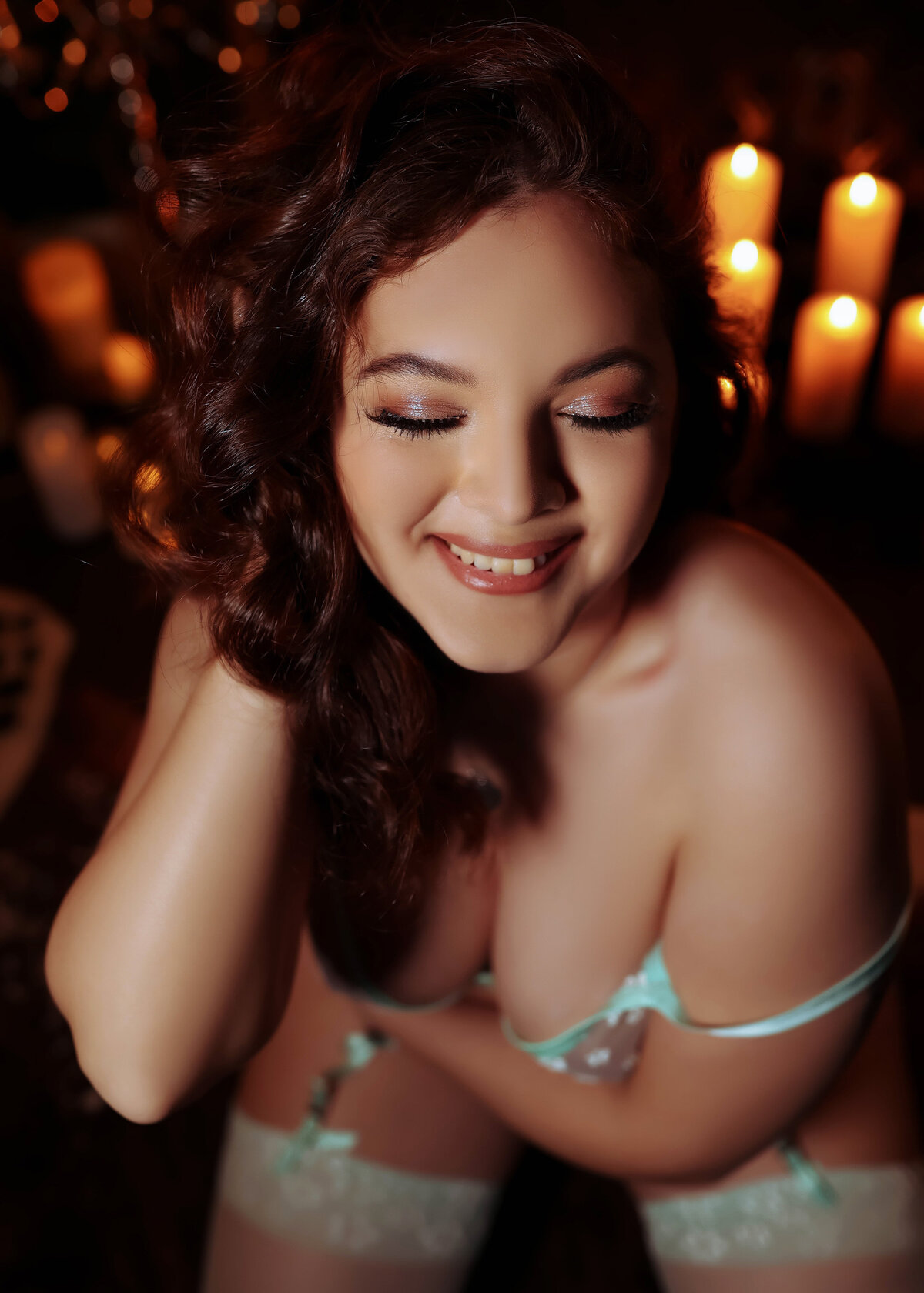 woman laughing and smiling during boudoir session in light blue lingerie