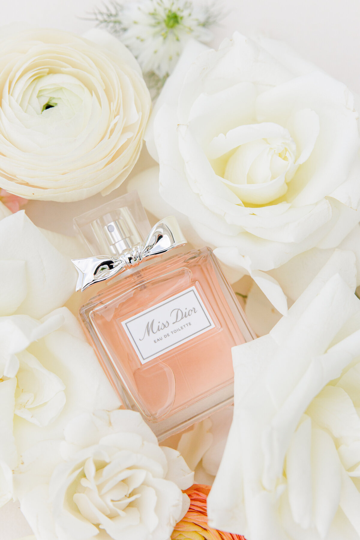 Pefume surrounded by white florals representing Christine Hazel Photography's attention to detail
