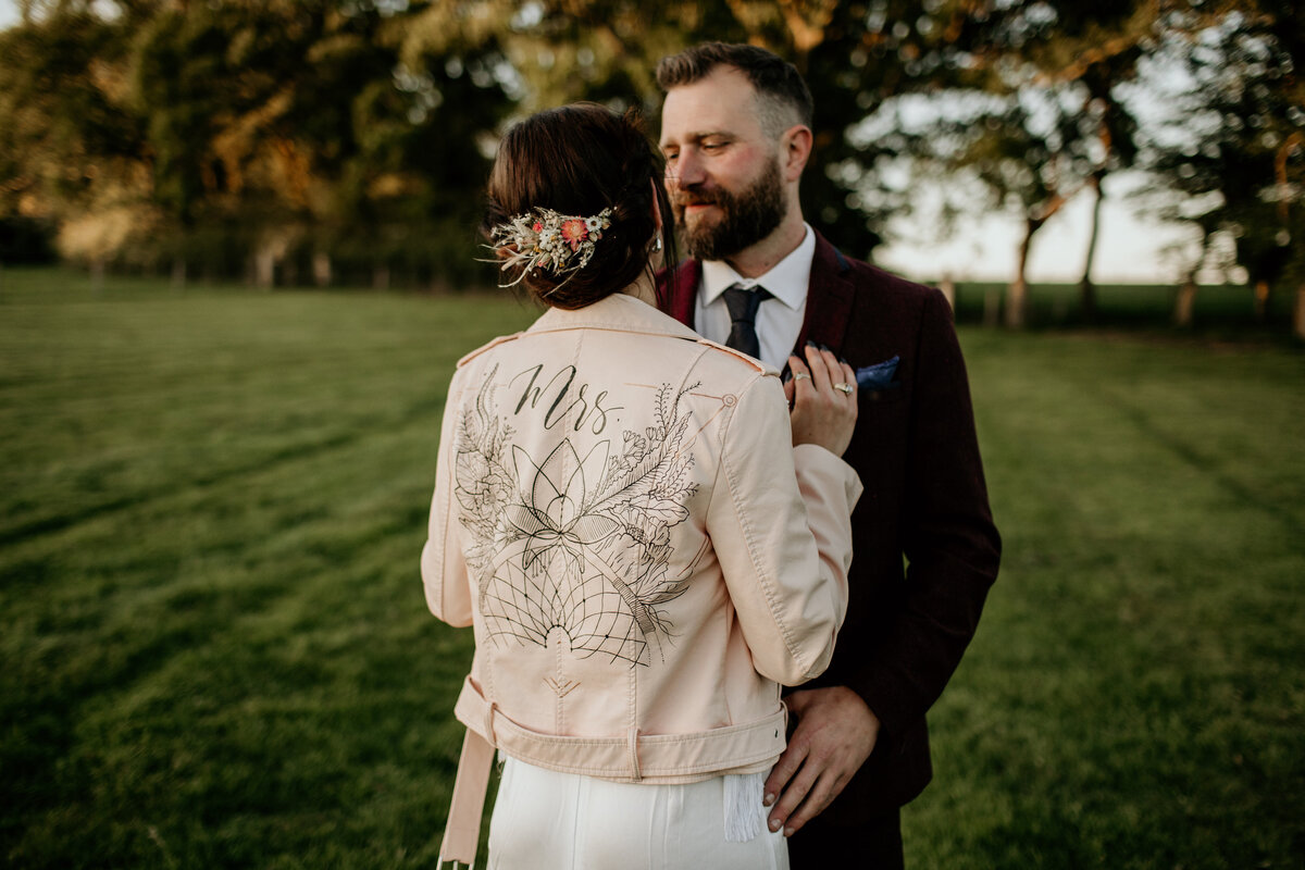 wedding couple with bride wearing nude leather jacket and botanical painted design