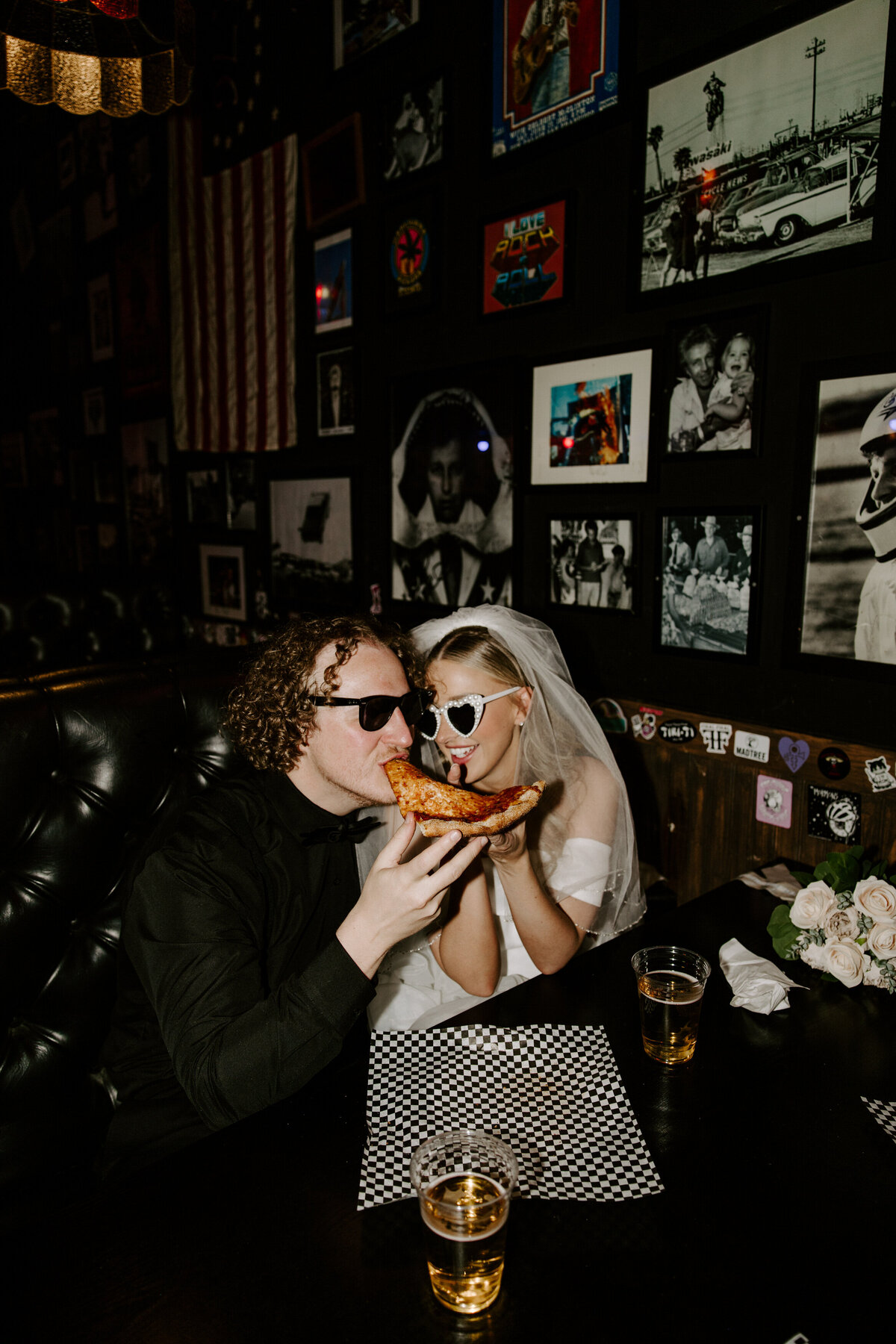 A couple shares a slice of pizza on their elopement day in Las Vegas.