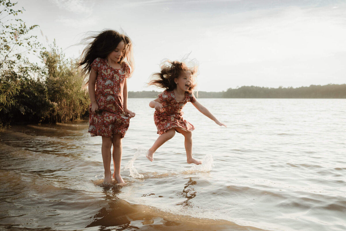 two girls jumping and laughing in the water