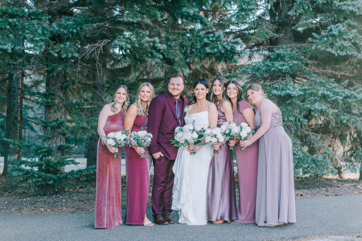 Bride is standing with all her bridesmaids and man of honour. 