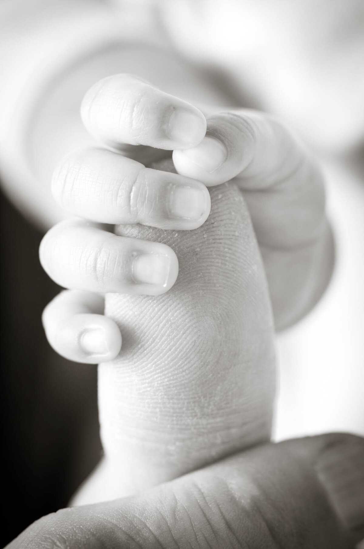 Newborn baby holding thumb-1