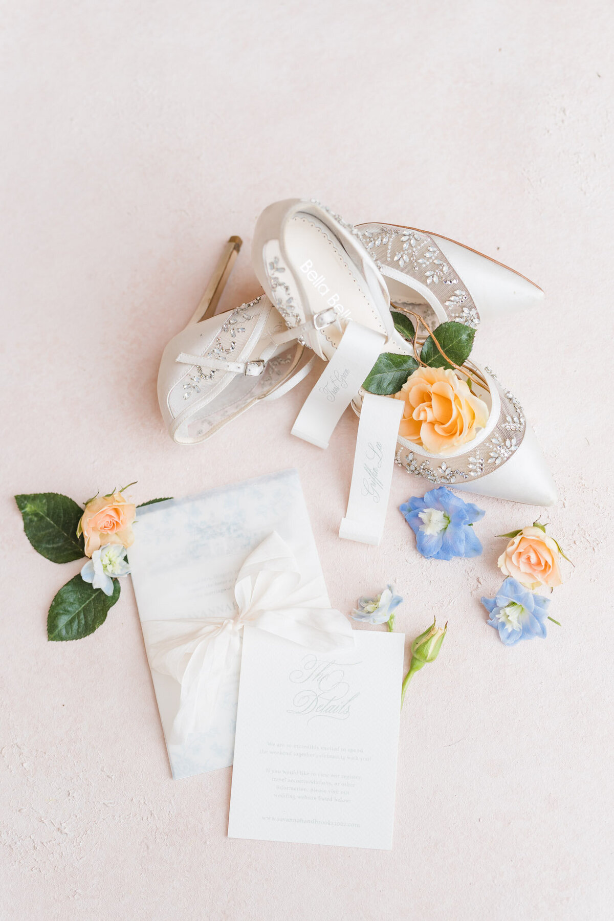 Detail photo of invitation suite and brides shoes
