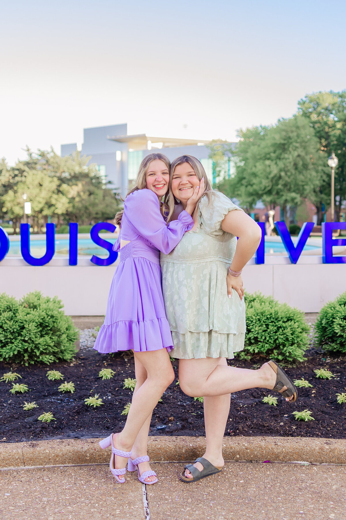 2 friends in SLU sorority hugging in front of the saint louis university sign