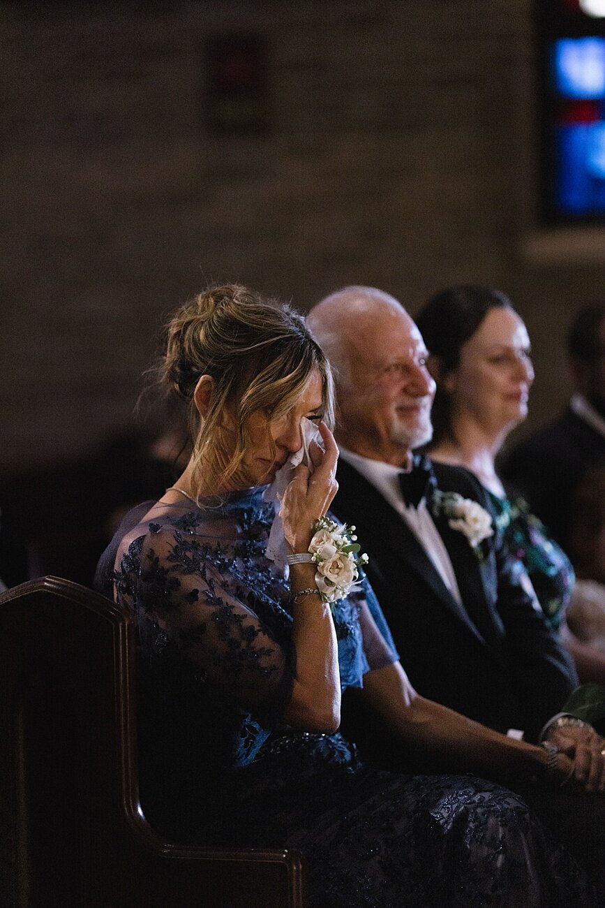 woman wiping tear with tissue during wedding ceremony